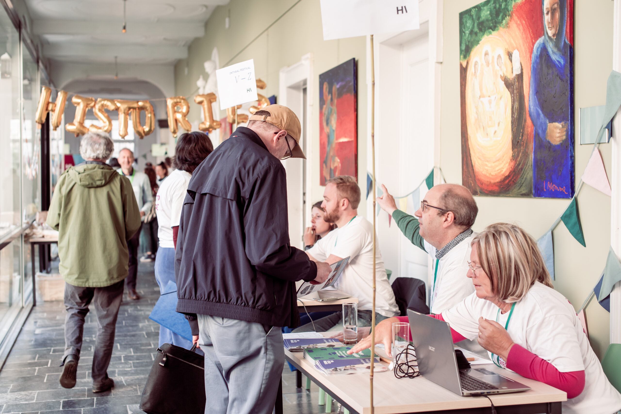 Mensen melden zich aan op het Histories Festival en krijgen uitleg van Histories medewerkers