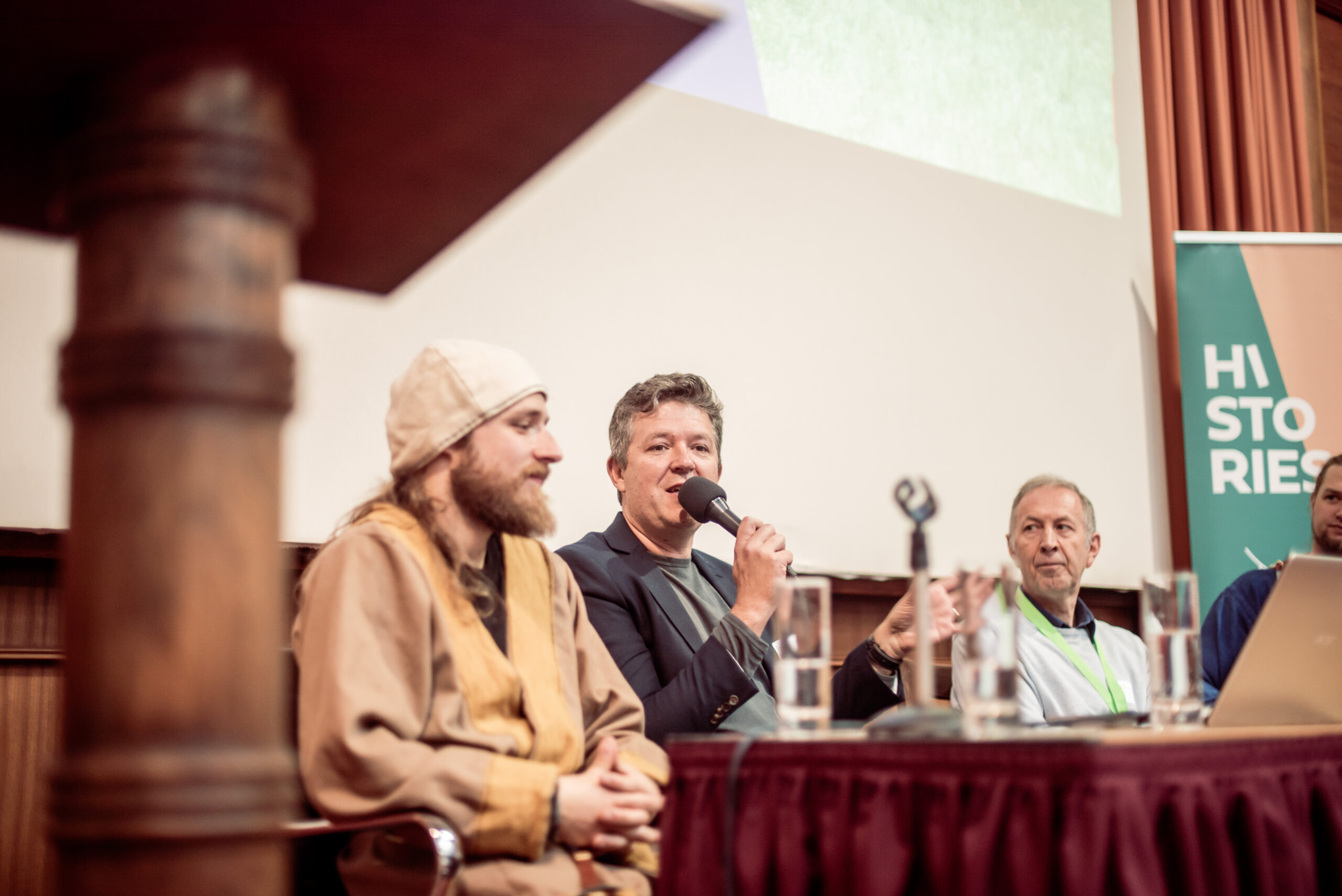 Een man spreek in een microfoon tijdens een panelgesprek