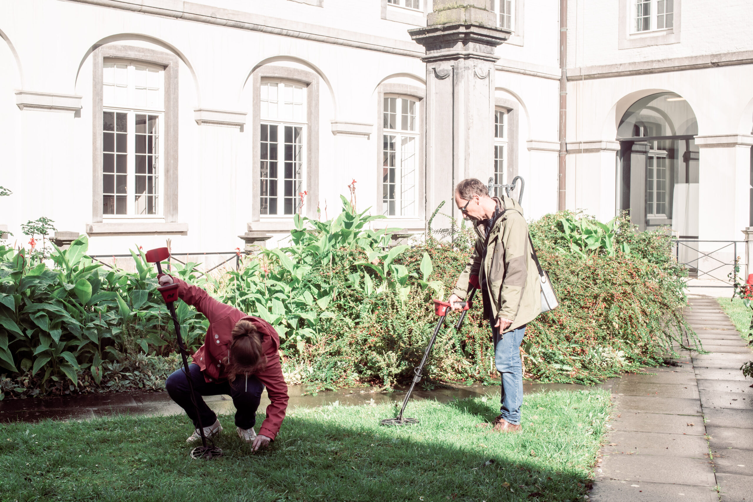 Twee mensen proberen metaaldetectie uit in de binnentuin van het Histories Festival