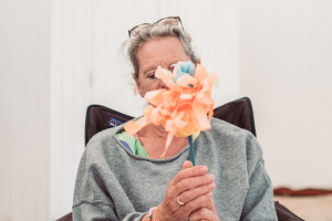 Vrouw met strandbloemen voor een strandcabine