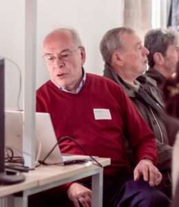 Een man zit achter een laptop.