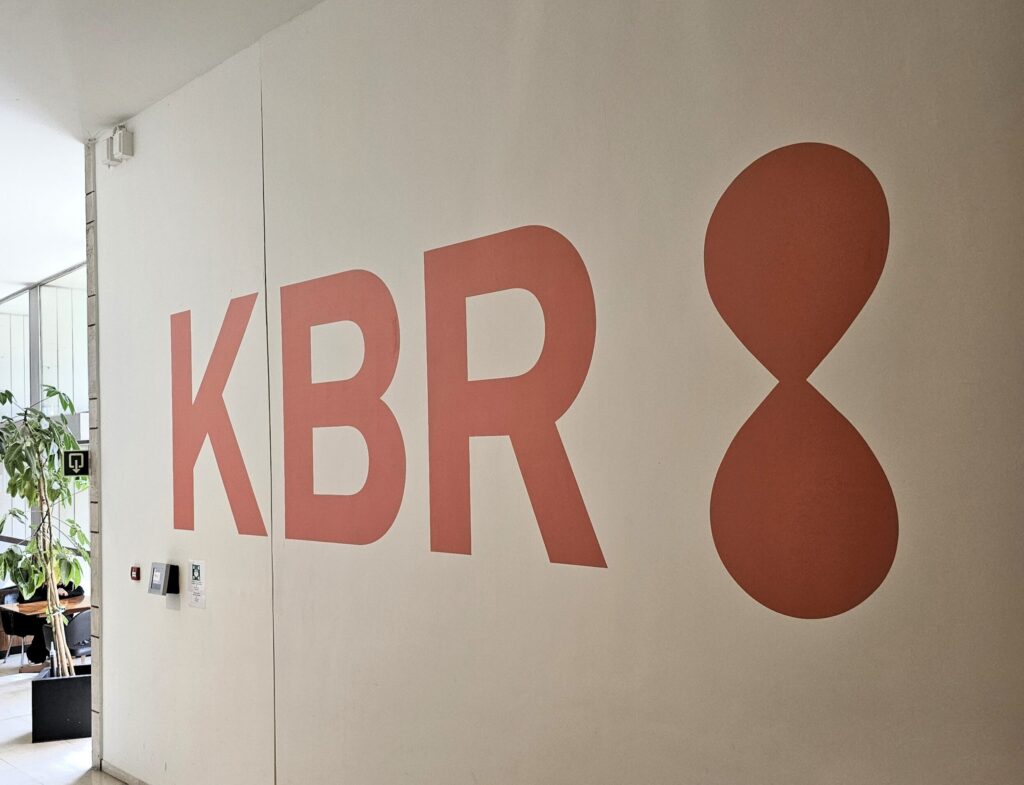 Rood logo van KBR in Brussel op witte muur.