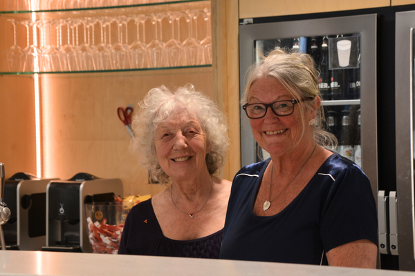 Twee vrouwen staan glimlachend op de foto.