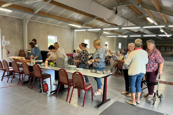 Een groep vrouwen schuift aan aan een buffet.